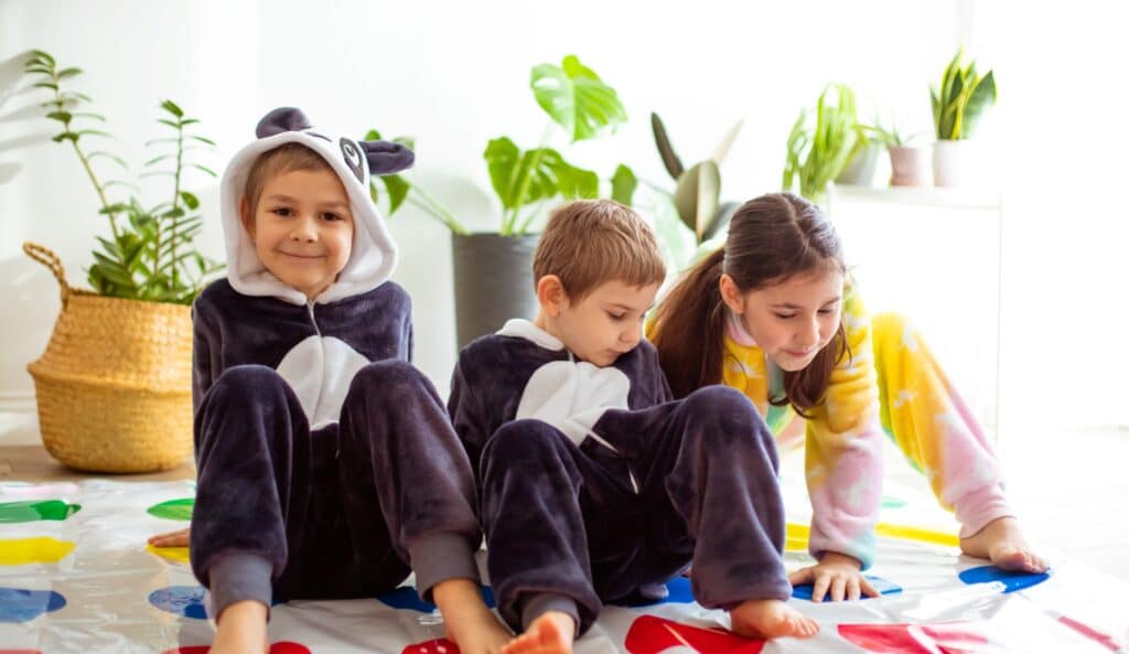 children-dressed-animal-kigurumi-sitting-floor-room-kids-pajamas-play-twister